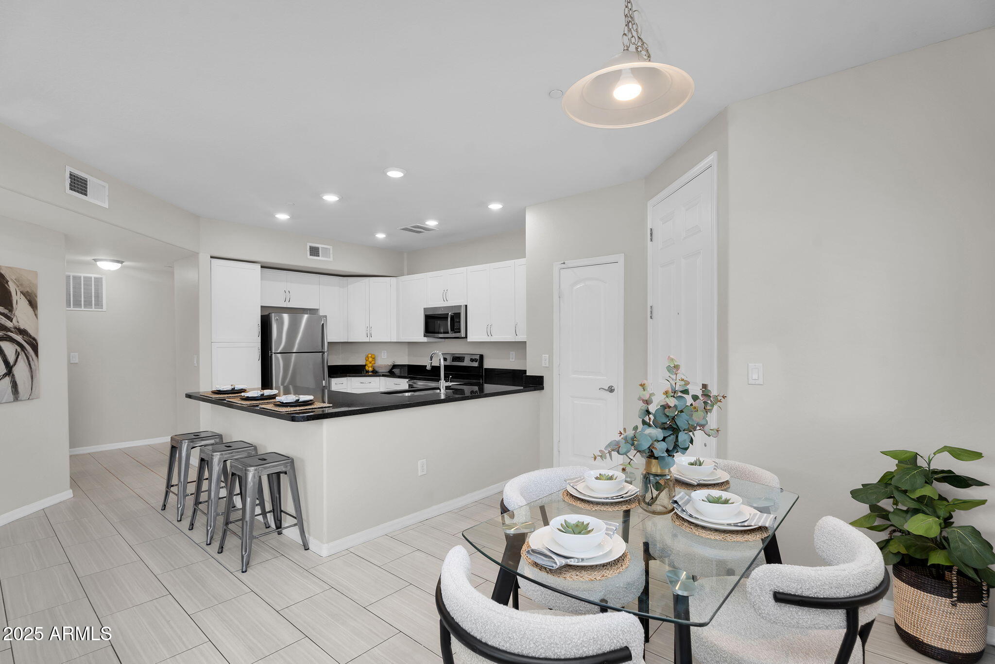 3330 South Gilbert Road, Unit 1075 Chandler, AZ 85286 - Photo 16 of 70 a kitchen with stainless steel appliances kitchen island granite countertop a dining table and chairs