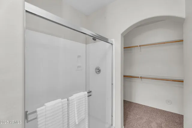 an empty room with closet and a chandelier fan