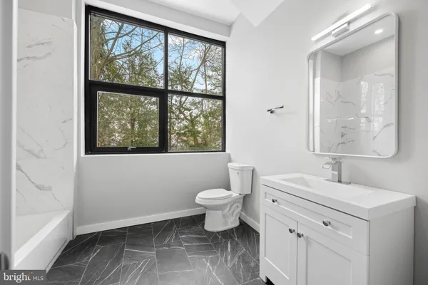 a bathroom with a toilet sink and window