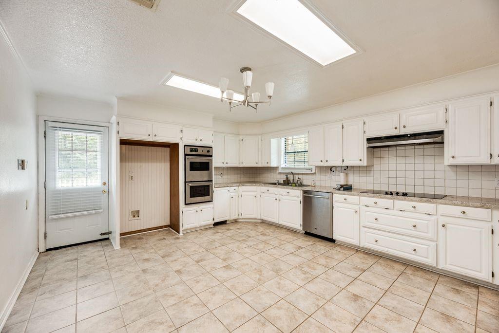 298 Butterfield Road Denison, TX 75021 - Photo 20 of 34 Kitchen featuring white cabinetry, tile flooring, built-in double ovens, a flat-top stove, and a stainless steel dishwasher