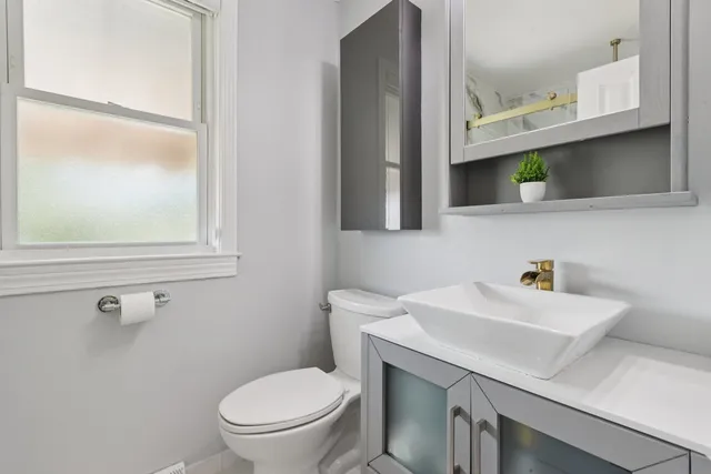 a bathroom with a sink a toilet and mirror