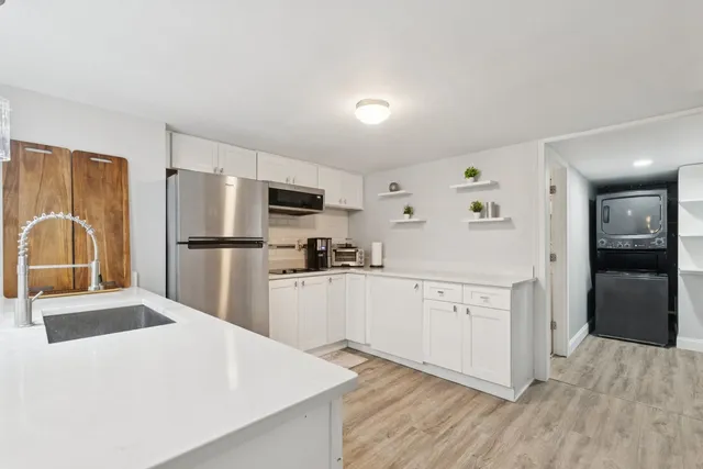 a kitchen with white cabinets and stainless steel appliances