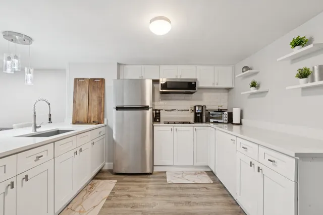 a kitchen with white cabinets and stainless steel appliances