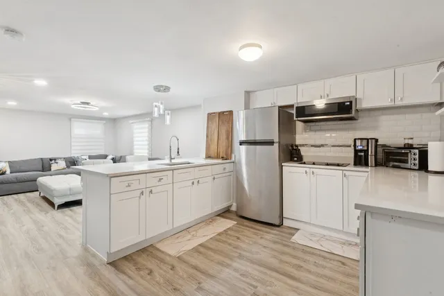 a kitchen with white cabinets and stainless steel appliances