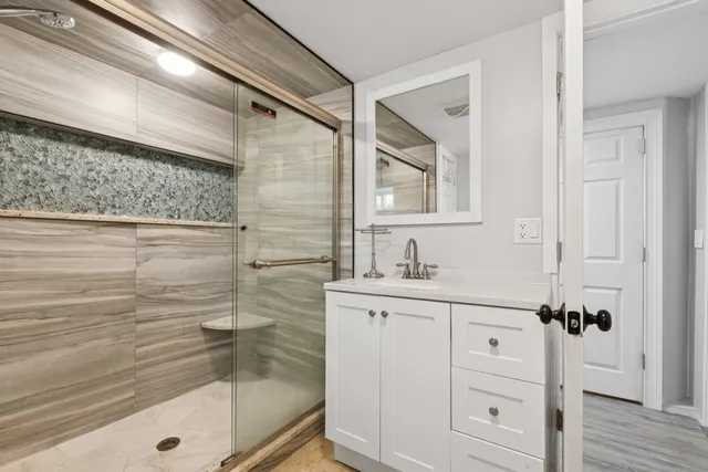 a bathroom with a shower sink and mirror