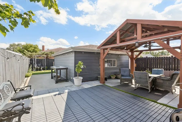 a view of a patio with table and chairs with wooden floor and fence