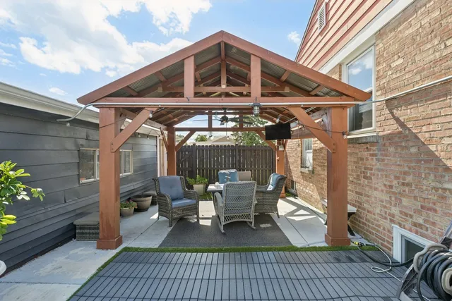 a front view of a house with a chairs and table in a patio