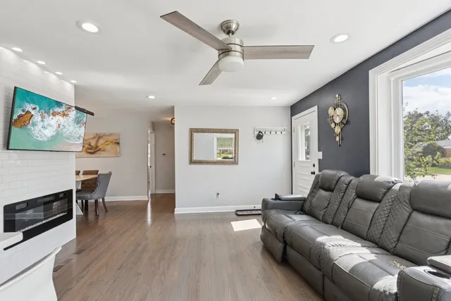 a living room with furniture a flat screen tv and a window