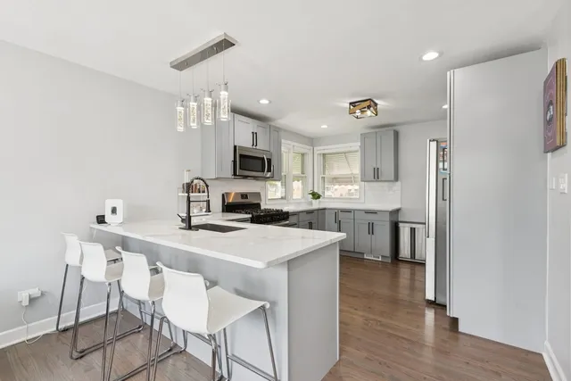 a kitchen with stainless steel appliances a stove top oven a sink refrigerator and microwave