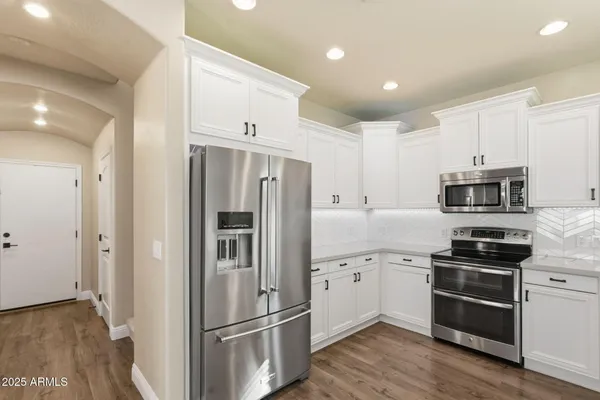 a kitchen with stainless steel appliances a refrigerator sink and microwave