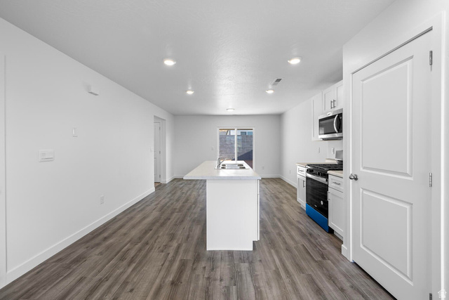 1597 South Fins Road, Unit 4177 Washington, UT 84780 - Photo 6 of 33 Open-concept living space featuring wood-finish flooring, recessed lighting, and a kitchen island with an integrated sink