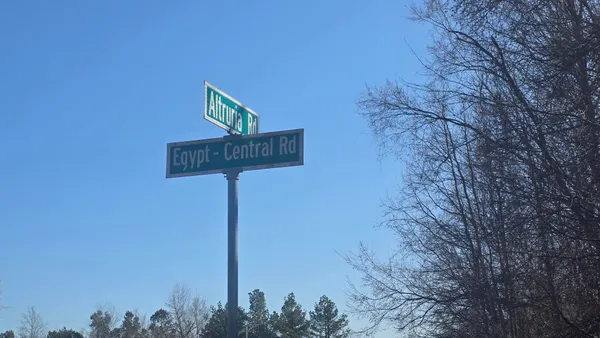 a street sign on a wall next to a road
