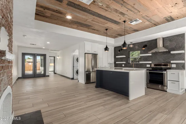 a large kitchen with stainless steel appliances granite countertop a large stove a sink dishwasher and a refrigerator with wooden floor