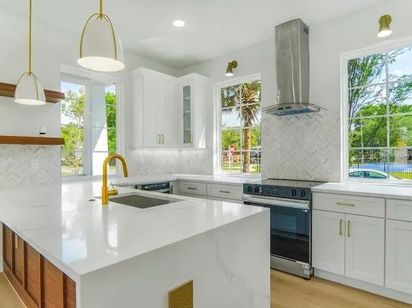 a kitchen with a sink a counter top space stainless steel appliances and a window