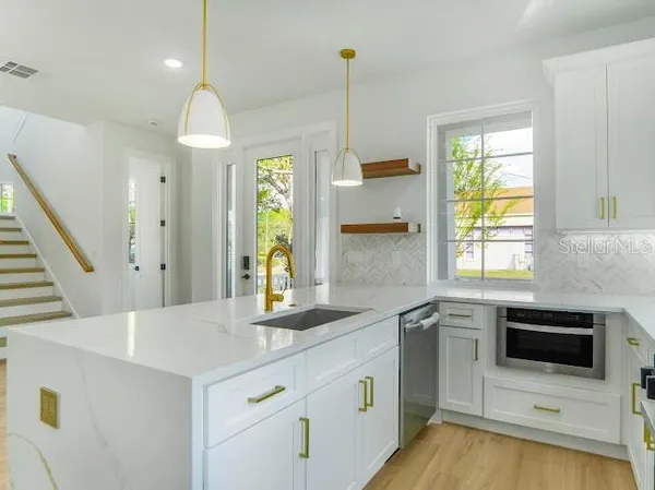 a kitchen with stainless steel appliances granite countertop a refrigerator and a sink