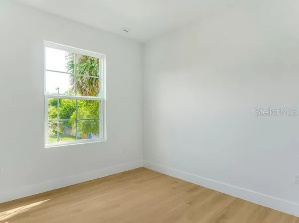 a view of an empty room with wooden floor