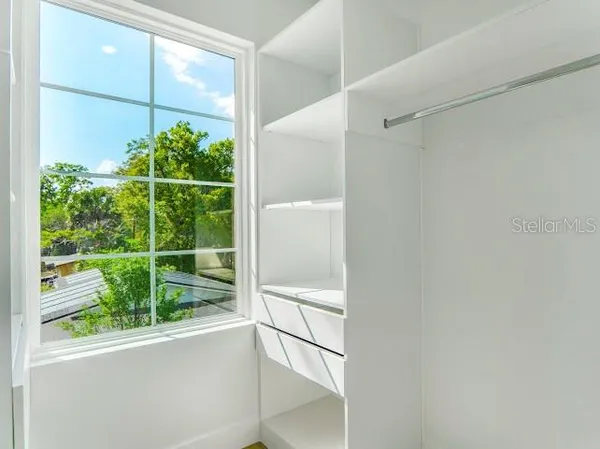 a view of yellow house with a big yard plants and large trees