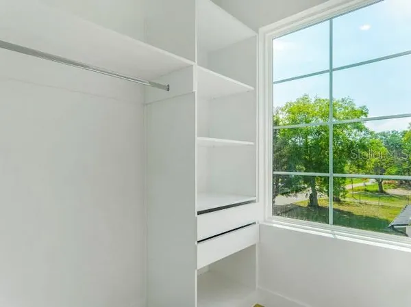 a view of a white house with large windows and a large tree
