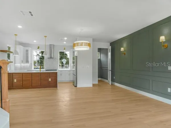 a large kitchen with kitchen island white cabinets and stainless steel appliances