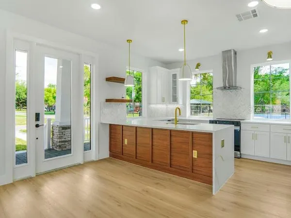 a kitchen with stainless steel appliances granite countertop a refrigerator a sink and a stove