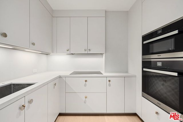 a kitchen with white cabinets and oven