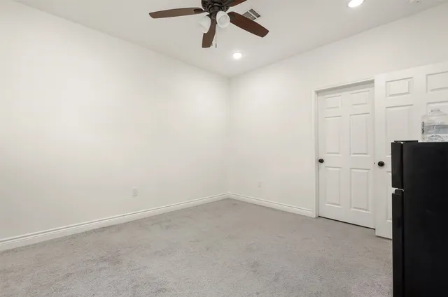 an empty room with a ceiling fan and a window