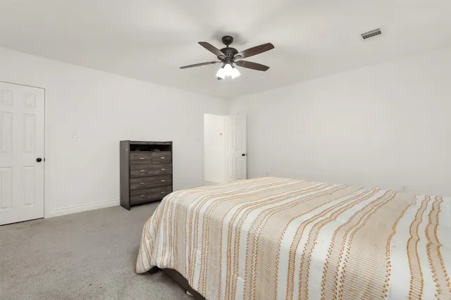 a bedroom with a bed and a ceiling fan
