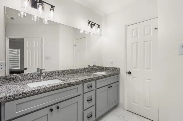 a bathroom with a granite countertop sink and a mirror