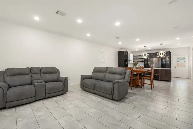 a living room with furniture and kitchen view