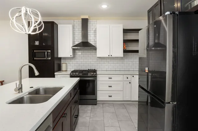 a kitchen with stainless steel appliances a sink stove and refrigerator