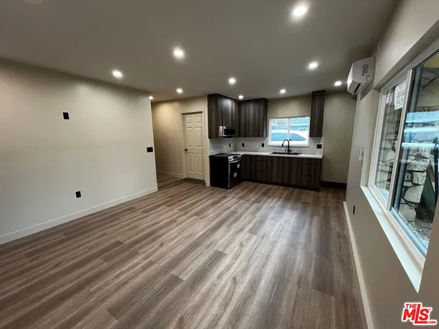 a large kitchen with stainless steel appliances kitchen island granite countertop a large window