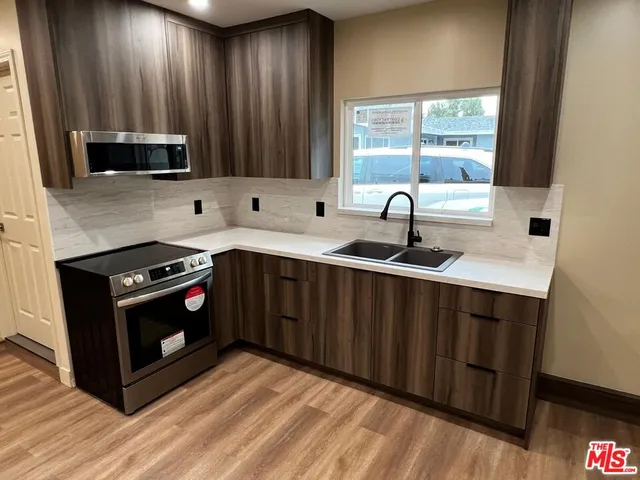 a kitchen with stainless steel appliances granite countertop a sink stove and microwave