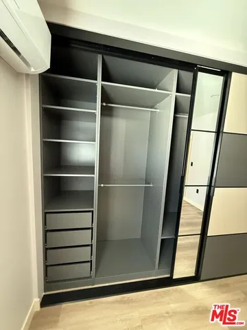 a view of walk in closet with empty racks