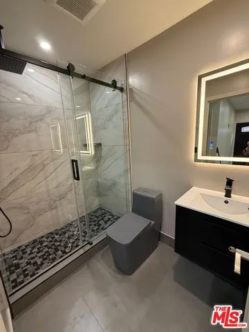 a bathroom with a sink toilet a mirror and shower