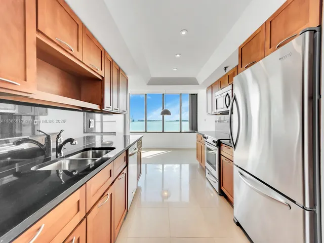 a view of a kitchen with a sink and refrigerator