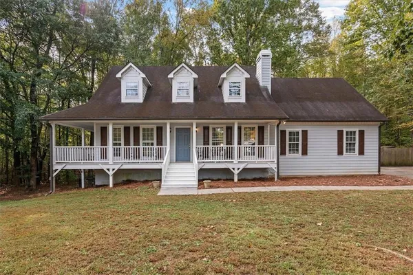a front view of a house with a garden and lake view