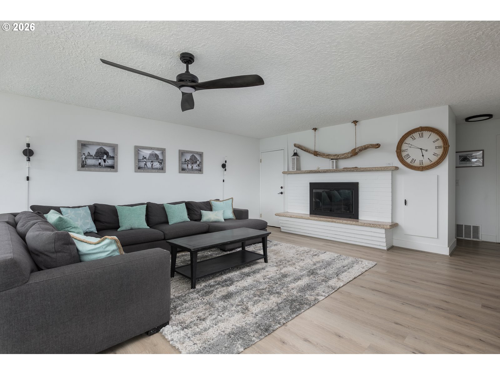 3087 South Hemlock Street Cannon Beach, OR 97110 - Photo 11 of 48 a living room with furniture a clock and a fireplace