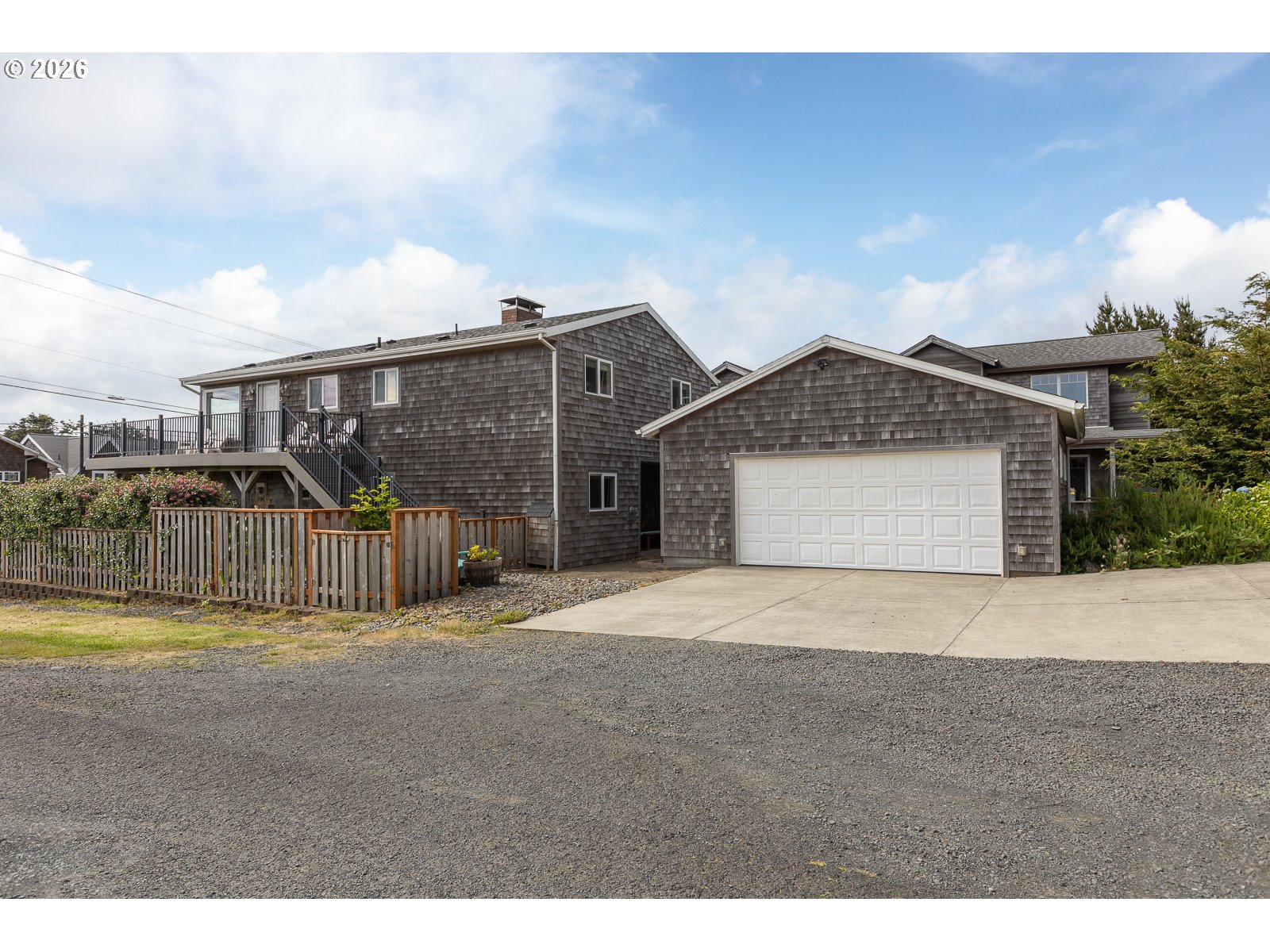 3087 South Hemlock Street Cannon Beach, OR 97110 - Photo 2 of 48 a front view of a house with a yard and garage