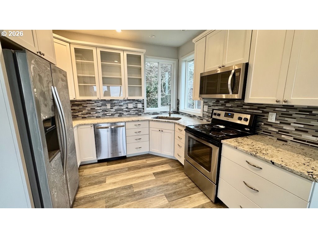 3087 South Hemlock Street Cannon Beach, OR 97110 - Photo 38 of 48 a kitchen with stainless steel appliances granite countertop a stove a sink and a refrigerator