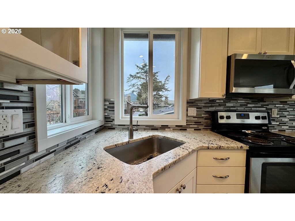 3087 South Hemlock Street Cannon Beach, OR 97110 - Photo 40 of 48 a kitchen with a stove a sink and a microwave