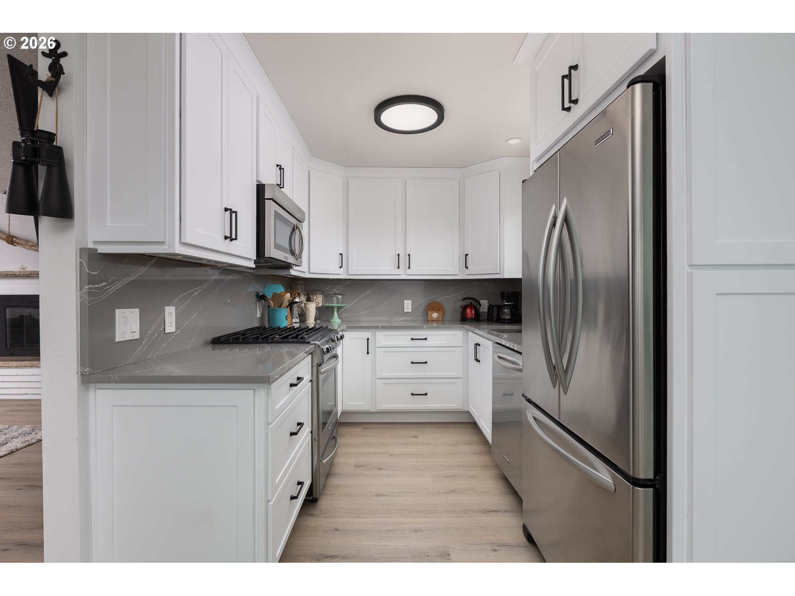 3087 South Hemlock Street Cannon Beach, OR 97110 - Photo 8 of 48 a kitchen with stainless steel appliances granite countertop a refrigerator sink and white cabinets