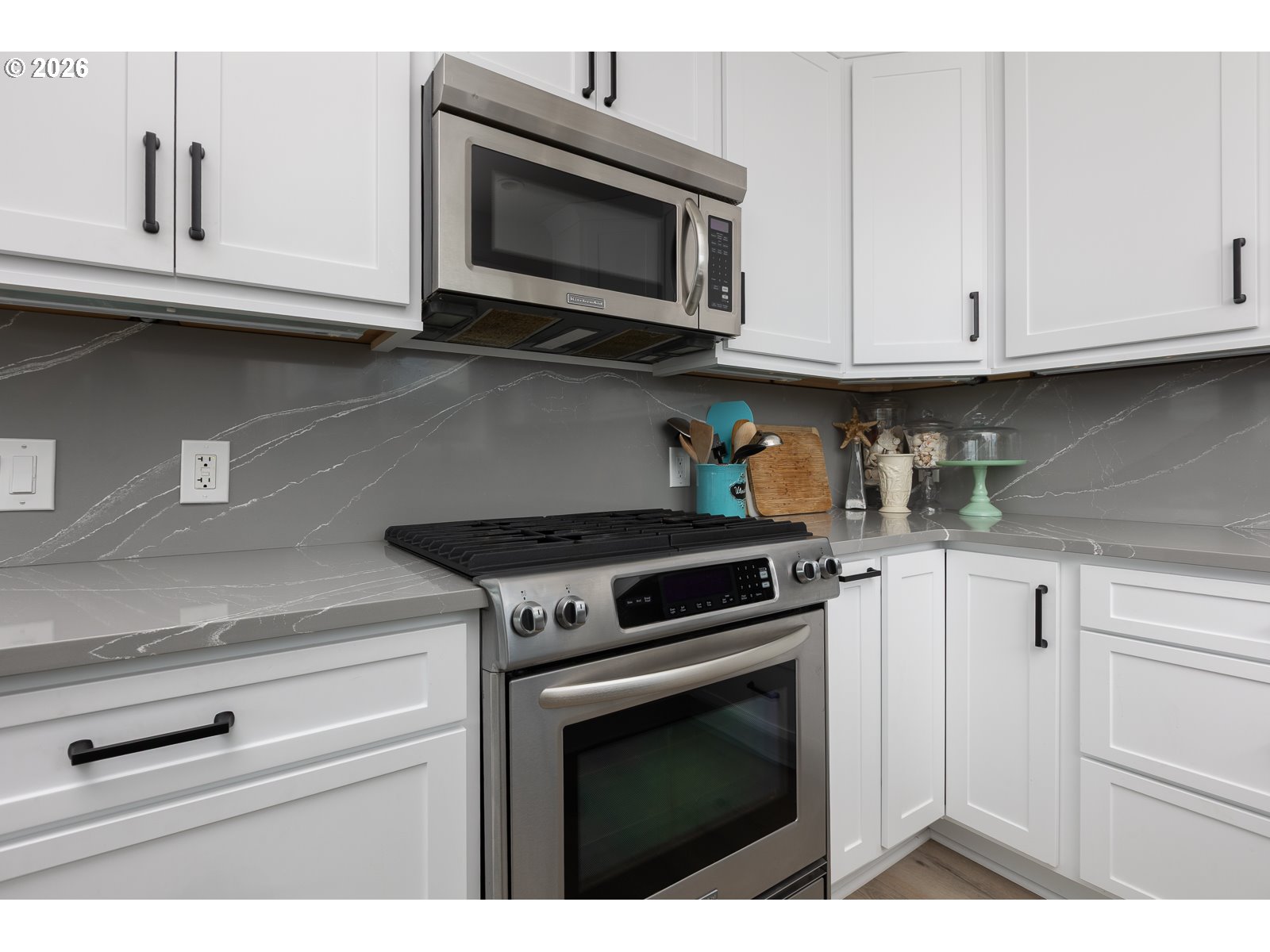 3087 South Hemlock Street Cannon Beach, OR 97110 - Photo 9 of 48 a kitchen with stainless steel appliances granite countertop white cabinets a stove top oven