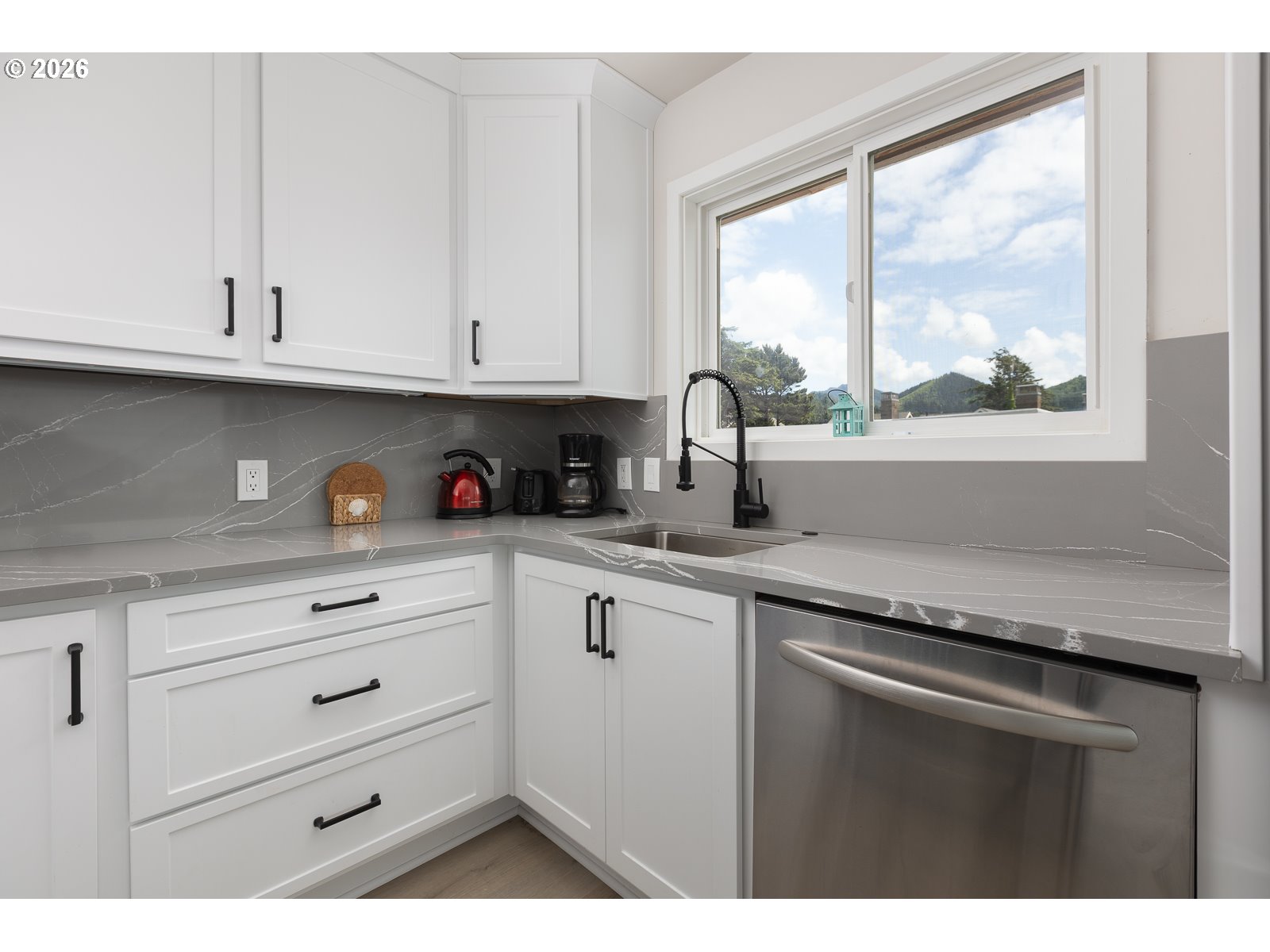 3087 South Hemlock Street Cannon Beach, OR 97110 - Photo 10 of 48 a kitchen with granite countertop white cabinets and a window