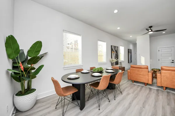 a dining room filled chandelier and wooden floor