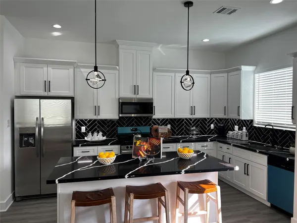 a kitchen with refrigerator and chairs