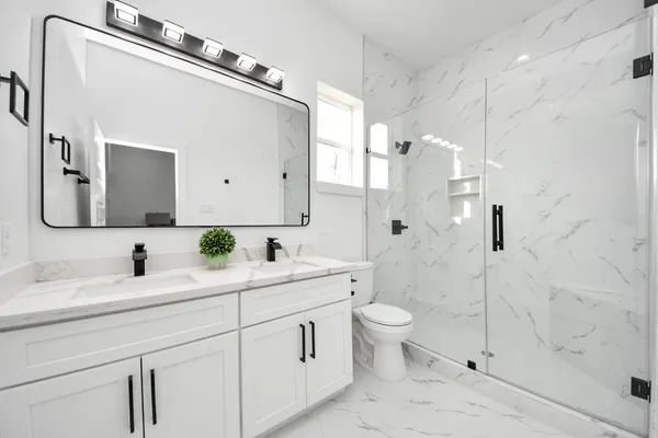 a bathroom with a double vanity sink mirror and toilet