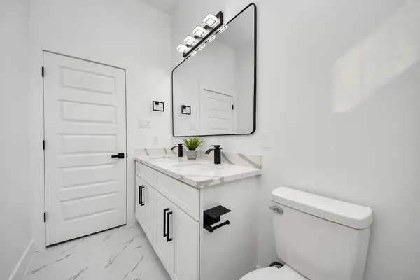 a bathroom with a granite countertop sink and a mirror