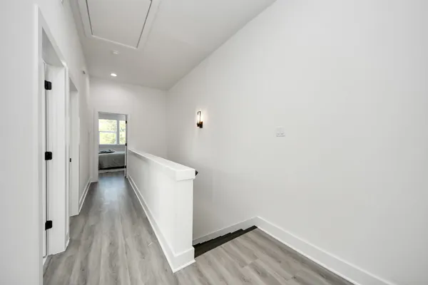 a view of a hallway with wooden floor and closet