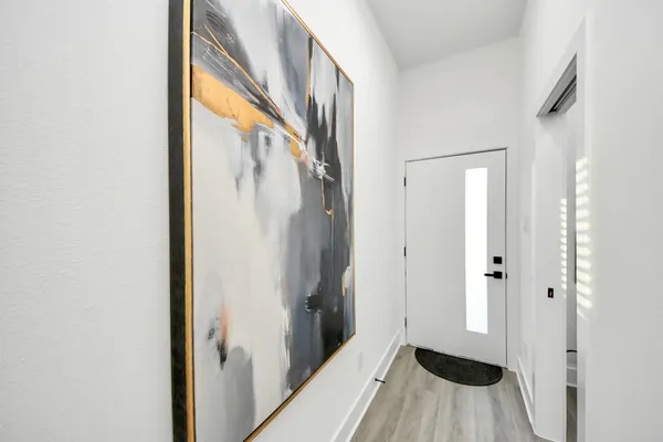 a view of a bathroom with a sink and a walk in closet with wooden floor