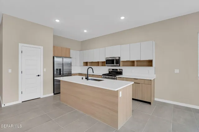 a kitchen with stainless steel appliances a refrigerator stove microwave and sink